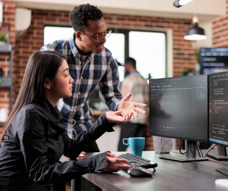 Two people looking at cyber security on screens.png